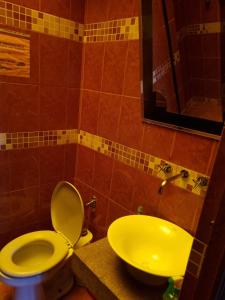 a bathroom with a yellow toilet and a sink at Hostal Imperial Carlos V in Potosí