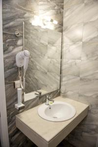 a bathroom with a sink and a mirror at Hotel Monte Cristo in Blagoevgrad