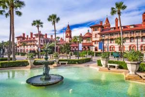 a fountain in front of a building with palm trees at 2 Bed/2 Bath Beach Condo in Saint Augustine