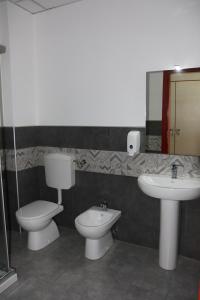 y baño con aseo, bidet y lavamanos. en Student's Hostel Parma, en Parma