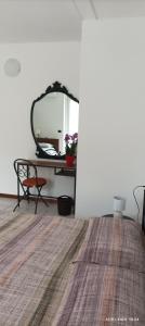 una stanza con specchio e tavolo con tappeto di 'L SASS a Borgomanero