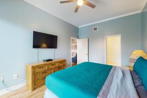 a bedroom with a bed and a flat screen tv at Salt & Serenity in Siesta Key