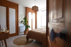 een slaapkamer met een bed, een raam en een spiegel bij At Huis in Boeschèpe