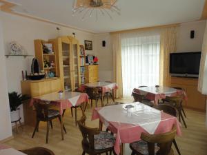 una sala da pranzo con tavoli, sedie e TV di Feistritzer a Seeboden Altre 37 foto