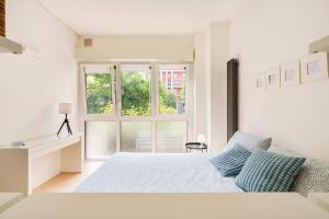 Habitación blanca con cama y ventana en Brand new large studio with parking - Opera studio en Milán