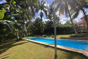 a swimming pool in a yard with palm trees at Casa Linda Villa 45 - Sosua in Sosúa