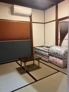 Habitación con cama y mesa. en ゲストハウスみんちゅう 