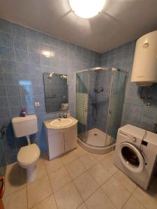 a bathroom with a toilet a sink and a shower at Maison Pero in Supetar