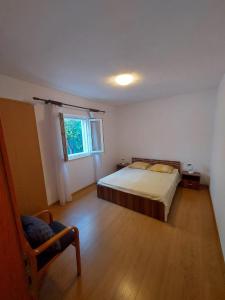 a bedroom with a bed and a window and a chair at Maison Pero in Supetar