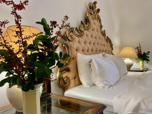 Un dormitorio con una cama ornamentada con un jarrón con una planta en Chateau la Bainerie, en Tiercé
