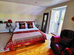 a bedroom with a large bed and a couch at Pheasants Retreat with Hot Tub and Fire Pit in Trefnant