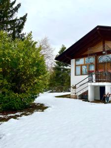 una casa con nieve frente a un edificio en La Villa del Barone, en Predaia