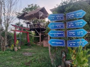 a street sign with arrows in front of a building at Doi Sang Farm Stay - ดอยซางฟาร์มสเตย์ in Ban Huai Kom