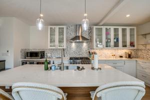 a kitchen with white cabinets and a kitchen island with two chairs at Central Napa Vacation Rental - Walk Downtown! in Napa