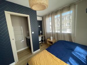 a bedroom with a blue bed and a mirror at Charmante maison rénovée en plein centre in Saint-Nazaire