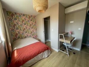 a small bedroom with a bed and a desk at Charmante maison rénovée en plein centre in Saint-Nazaire