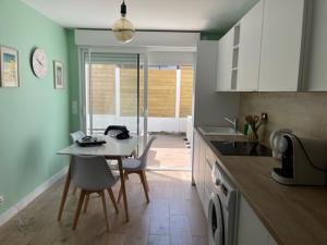 a kitchen with a table and a table and chairs at Charmante maison rénovée en plein centre in Saint-Nazaire