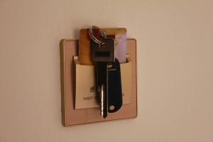 a cell phone holder on a wall at sobe Astonia in Subotica