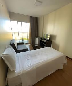 a hotel room with a white bed and a television at Ozped Private Flats Manhatan in Brasília +51 photos