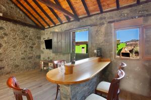 a bar in a room with a table and chairs at Villa Paraiso Aldeano 1+2 in La Aldea de San Nicolas