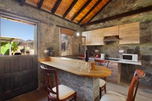 a kitchen with a wooden counter and a table at Villa Paraiso Aldeano 1+2 in La Aldea de San Nicolas