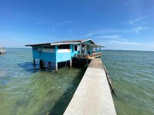 a blue house on a pier in the water at บ้านในทะเล (Baan Nai Talay) in Ban Ao Makham Pom