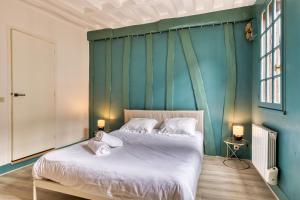 Damiette, charmant F4 centre Rouen St Maclou ! في رووين: غرفة نوم بسرير مع جدار ازرق