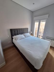 a large white bed in a bedroom with a window at Salamanca Views in Madrid
