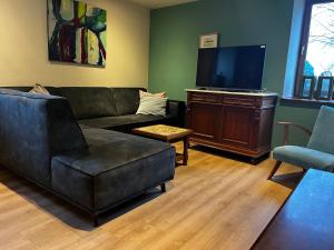 a living room with a couch and a flat screen tv at Holiday Homes Gillishof in Simpelveld