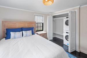 a bedroom with a bed and a washer and dryer at 3-min Walk To Beach! Private Luxury Backyard! in Dennis