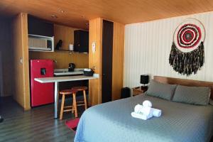Cet appartement comprend une chambre avec un lit et une petite cuisine. dans l'établissement La Casona Caburgua, à Pucón