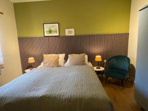 sypialnia z łóżkiem i zielonym krzesłem w obiekcie Holiday Homes Gillishof w mieście Simpelveld