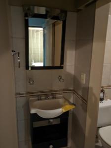 een badkamer met een wastafel en een spiegel bij Inmuebles Elías in La Cieneguita