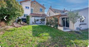 a house with a yard with a chair in it at Un bol d'air frais près de Paris in Eaubonne