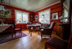 un soggiorno con pareti rosse, tavolo e sedie di Røisheim Hotel & Skysstasjon a Lom