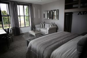 a bedroom with a bed, chair, and window at The Eccleston Hotel; BW Signature Collection in Saint Helens