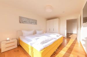 um quarto com uma cama grande e lençóis brancos em Müritzblick Hafenresidenz em Waren