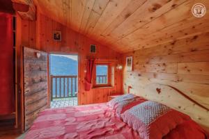 a bedroom with a bed in a wooden cabin at Le megevan-dans les alpages in La Giettaz