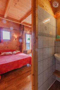 a bedroom with a bed and a sink in a cabin at Le megevan-dans les alpages in La Giettaz