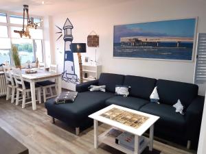 ein Wohnzimmer mit einem blauen Sofa und einem Tisch in der Unterkunft Ferienpark - Haus Q, App 0Q0402 in Heiligenhafen