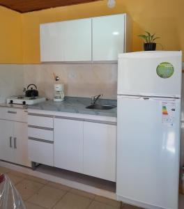 a kitchen with a white refrigerator and a sink at Cabaña Río Pulmarí in Aluminé