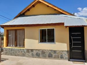 a small house with a metal roof and a door at Cabaña Río Pulmarí in Aluminé