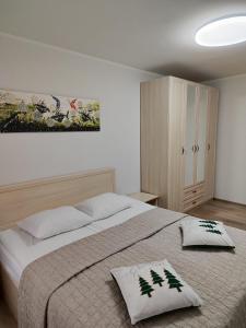una camera con un grande letto e un dipinto sul muro di Adelės apartamentai a Druskininkai