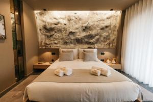 - une chambre avec un grand lit et des serviettes dans l'établissement Pousadela Village, à Vieira do Minho