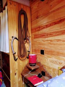 a bedroom with a wooden wall with two ropes at Mon petit Appartement Montagnard du Plateau in Saint-Hilaire