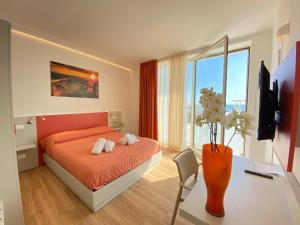 a bedroom with a bed and a desk with a vase at Bagno Luciano in Marina di Carrara