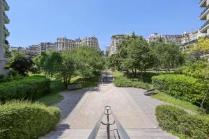um caminho num parque com edifícios ao fundo em Studio 25m indépendant Tour Eiffel em Paris