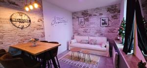 - un salon avec un canapé et une table dans l'établissement Le Clos Maldier - Gîte Les Ecureuils, à Laon
