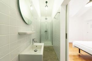 a white bathroom with a sink and a shower at Engenho Hostel in Lajes do Pico
