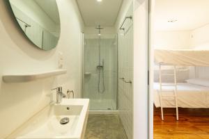 a bathroom with a shower and a sink and a mirror at Engenho Hostel in Lajes do Pico +49 photos